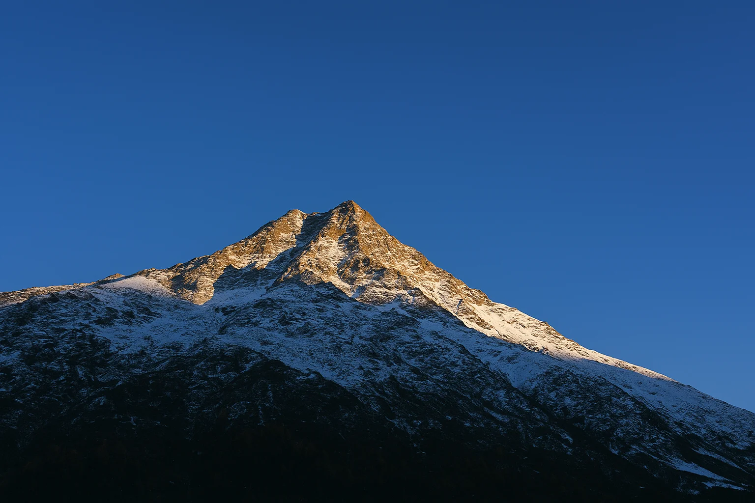 Snow-Covered Mountain Peak Shining in Sunlight