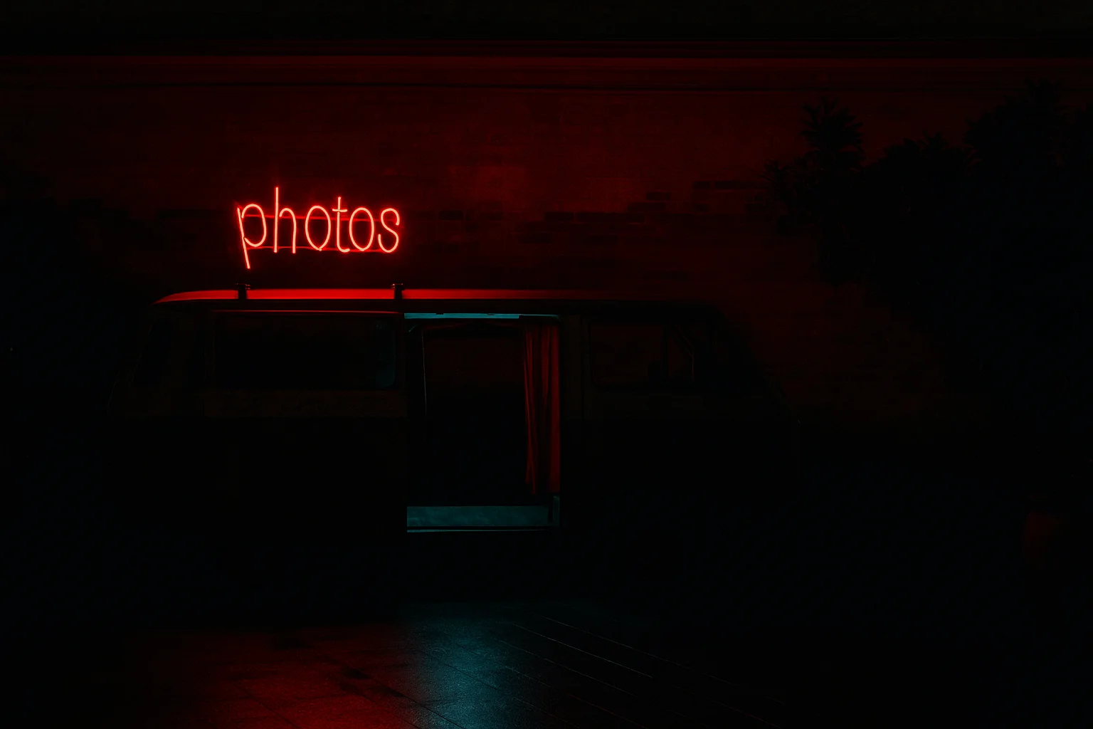 Memories in the Night Light: Neon “Photos” Sign on a Vintage Photo Van