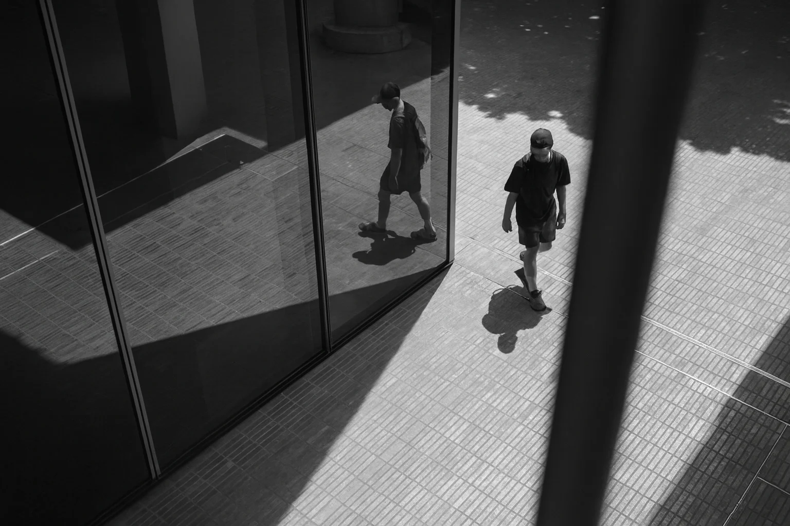 Black and White Reflection of a Walking Person in Modern Architecture
