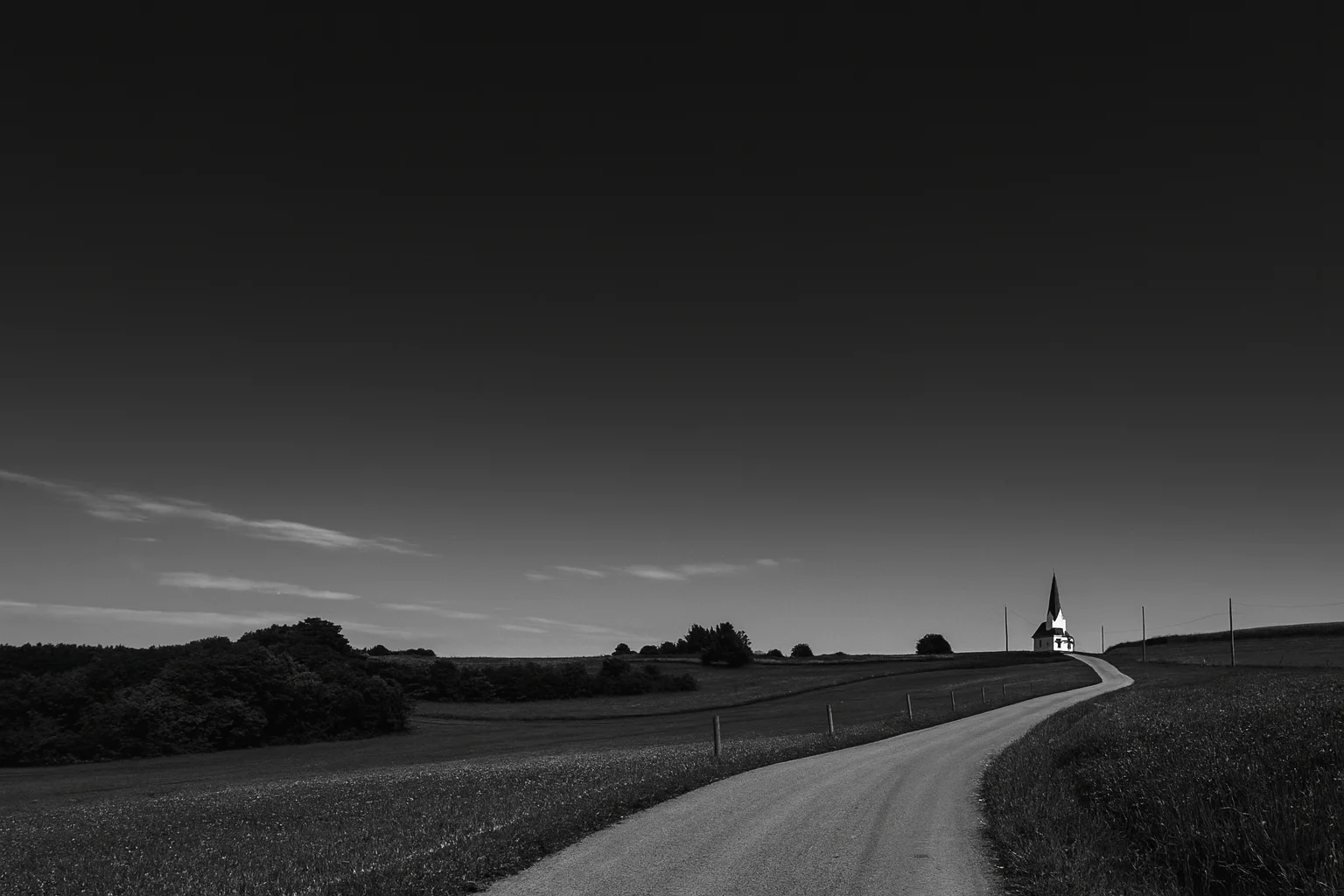 Rural Road Leading to the Horizon with a Small Distant Church – Black and White Landscape