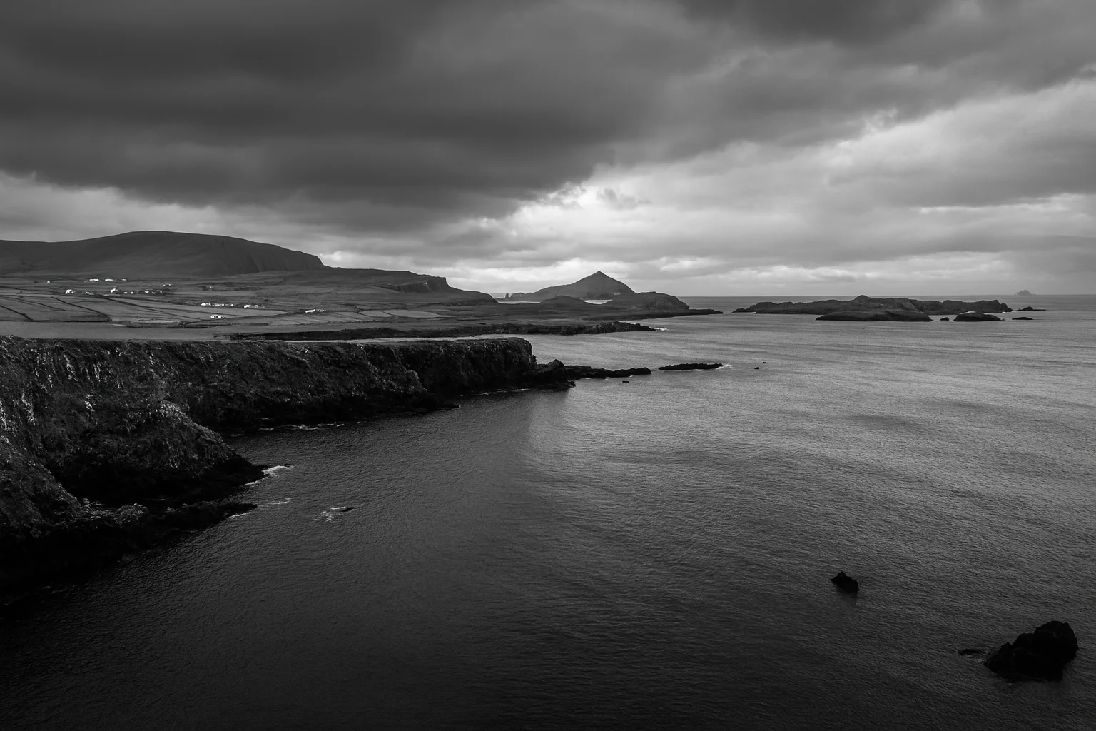 Coastal Cliffs and Sea Under Dramatic Clouds – Black and White Landscape