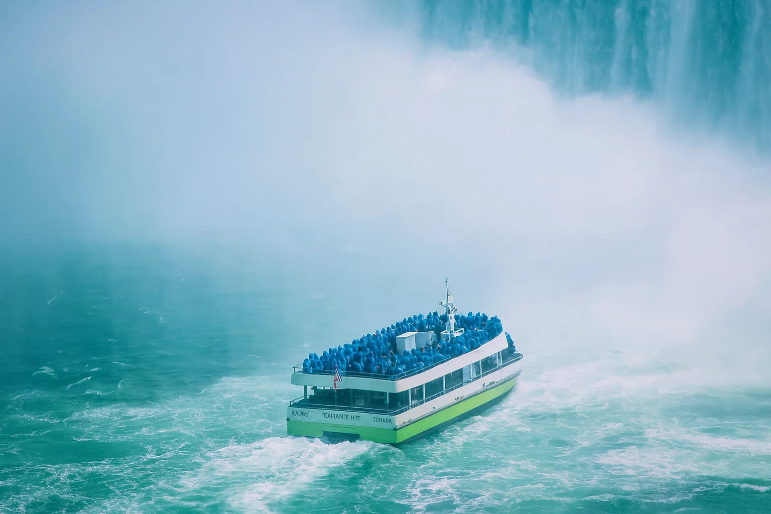 Tour Boat Moving Through Heavy Mist Near a Waterfall – Horizontal Nature Scene